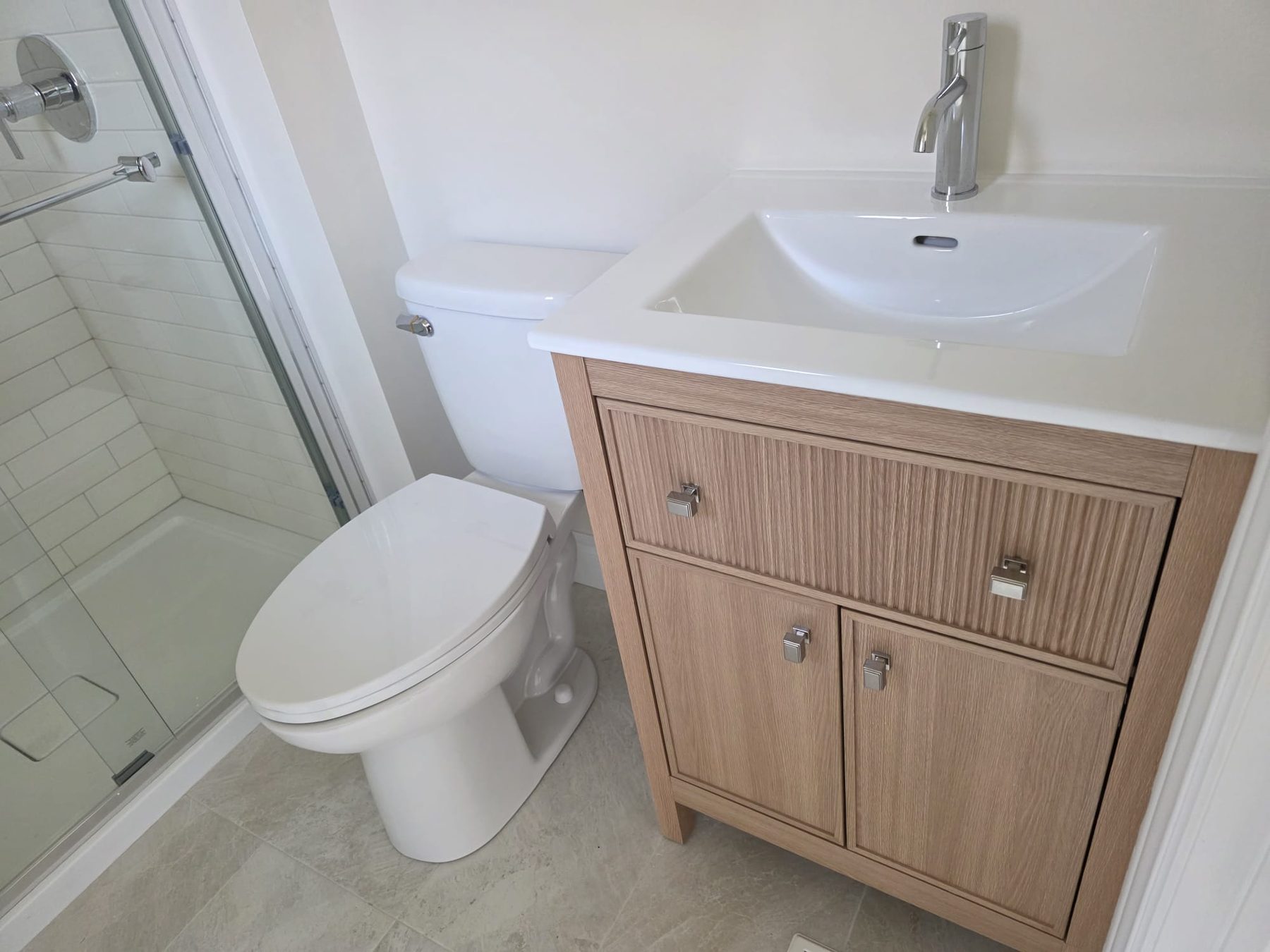 Finished bathroom with glass shower, new toilet and vanity