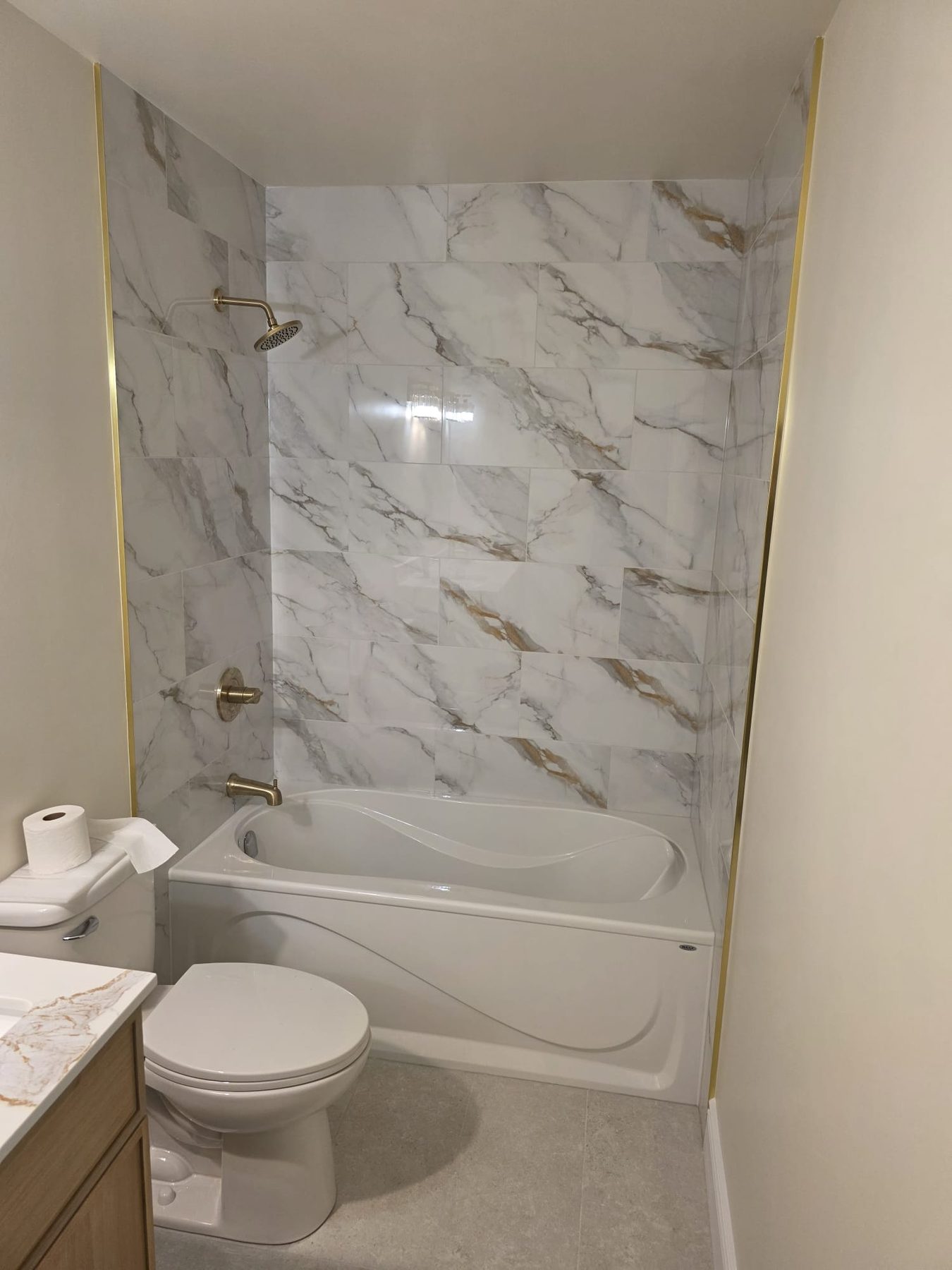 Finished bathroom with marble-look tub surround and new fixtures