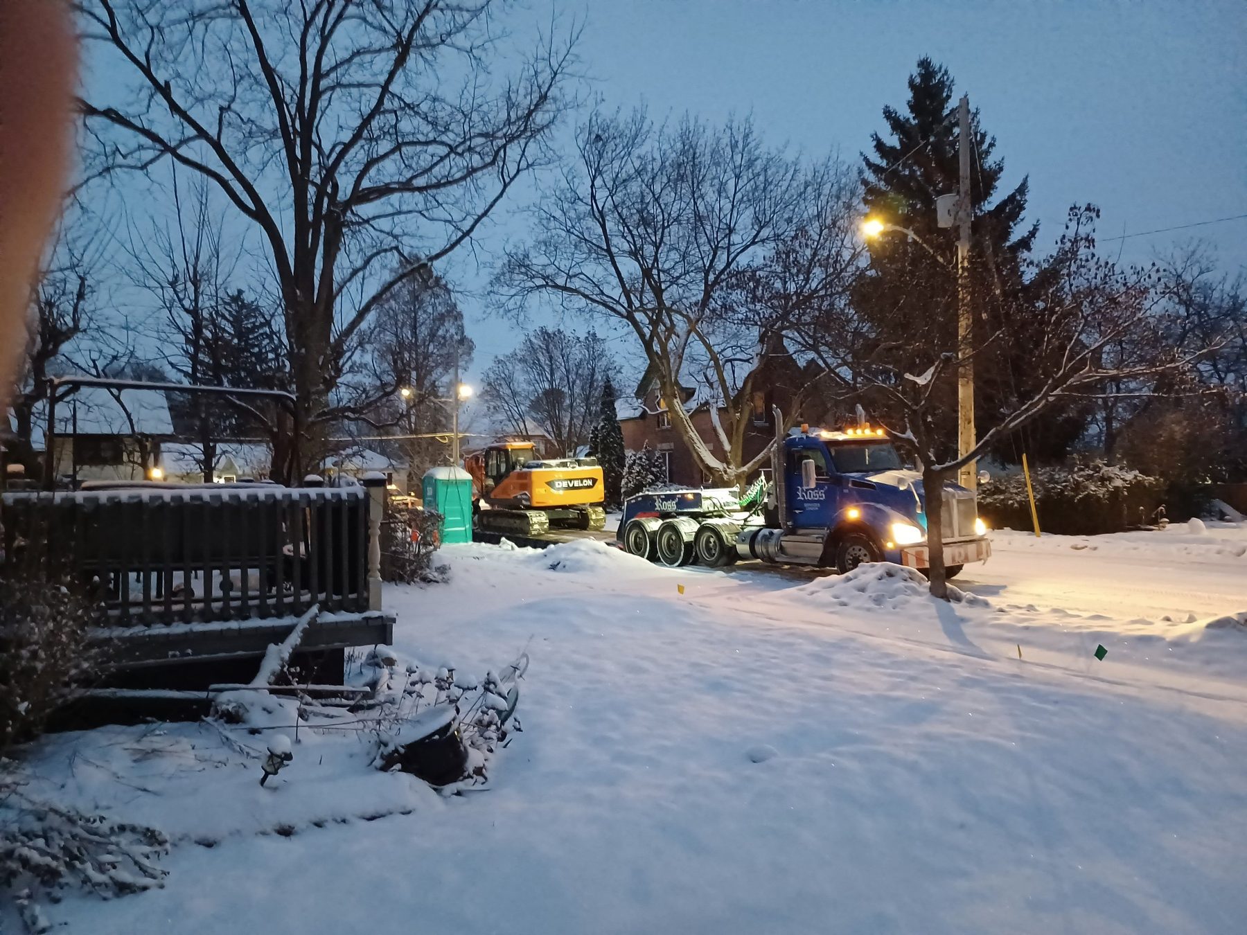 Excavator and truck replacing a sewer line on a London street